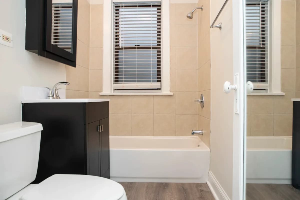 1251 W. Henderson St, Apt 1 — bathroom with dark vanity and tub-shower combo