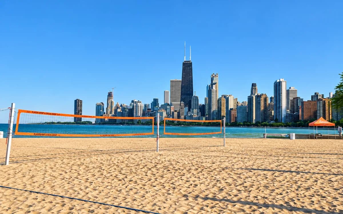 Sand volleyball courts on North Avenue Beach with the Chicago skyline rising across the water