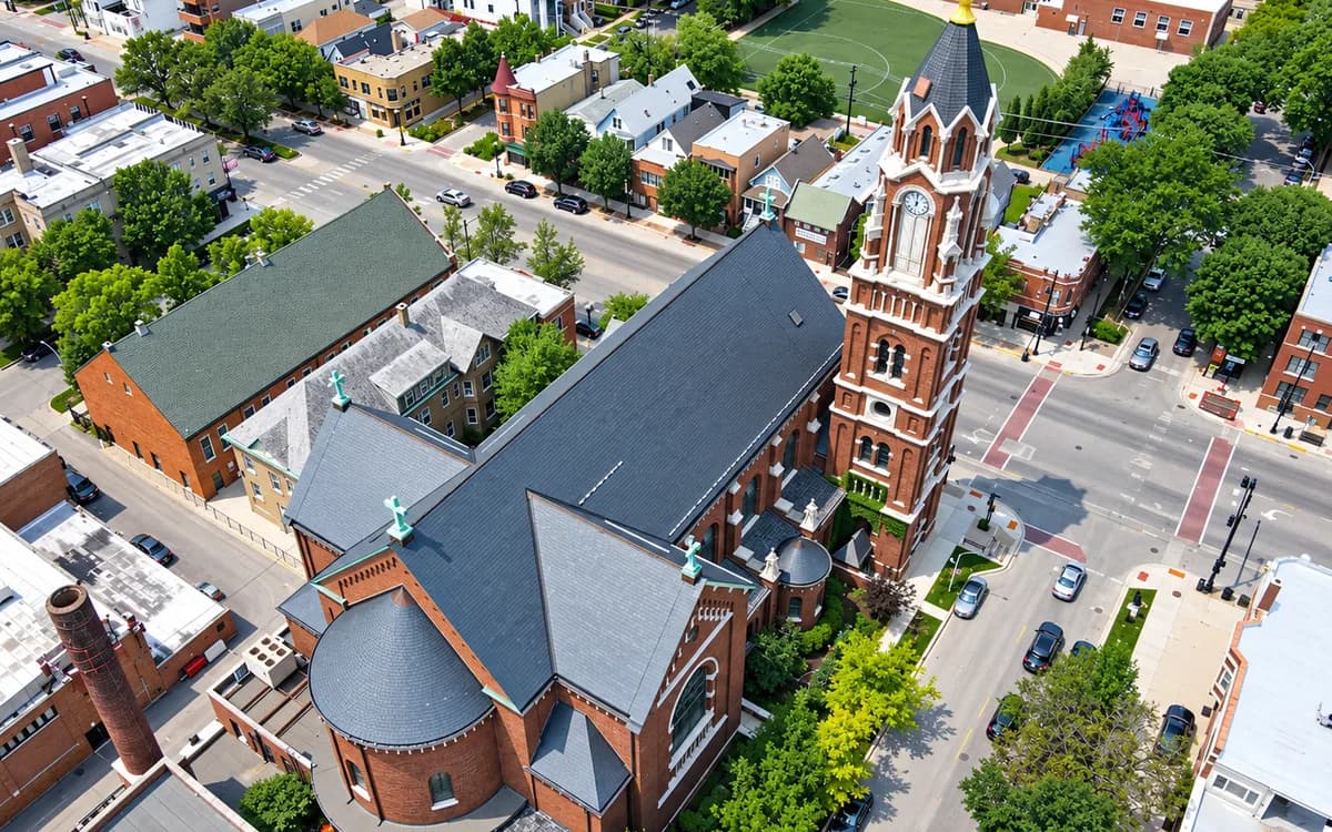 Aerial view of St. Benedict Parish's brick church and bell tower amid the surrounding streets